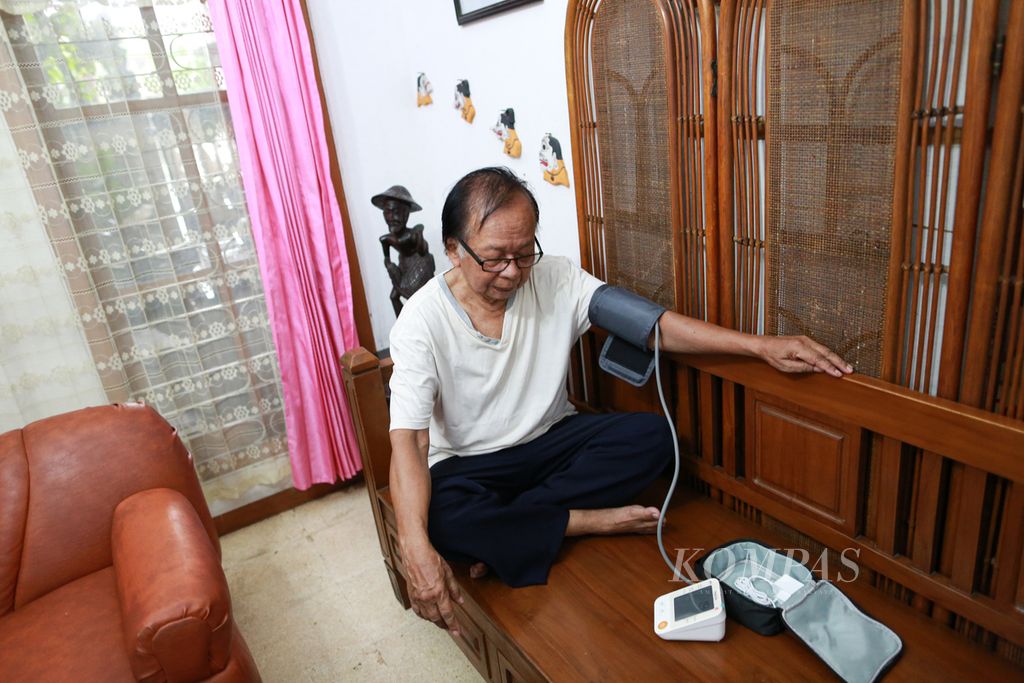 Mardonius Wagiman (73) atau dikenal dengan Jayeng secara mandiri memeriksa tekanan darah di kediamannya di kawasan Petukangan, Jakarta Selatan, Rabu (25/5/2022).
