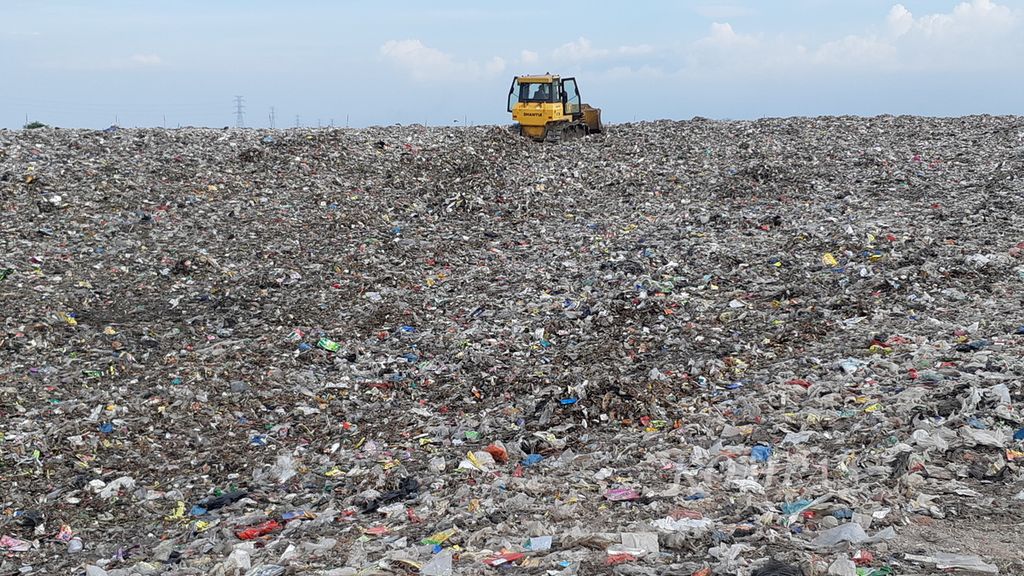 Seorang pekerja meratakan timbunan residu sampah rumah tangga menggunakan alat berat di Tempat Pemrosesan Akhir Jabon, Sidoarjo, Jawa Timur, Jumat (16/9/2022). Residu sampah ini akan diolah menjadi bahan bakar jumputan padat atau <i>refused dferived fuel</i> (RDF). 