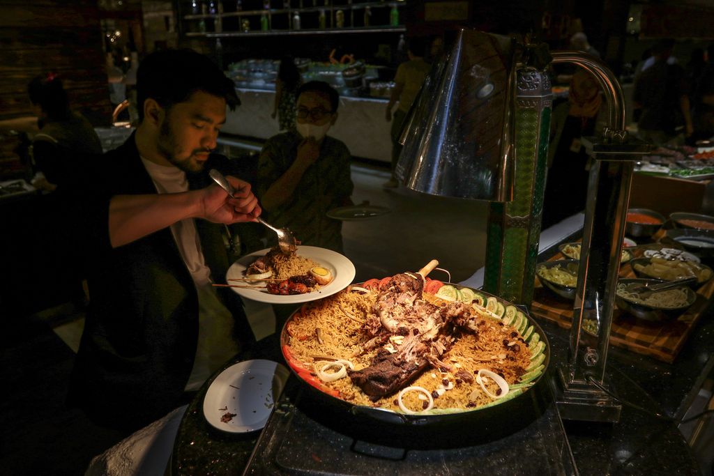 Seorang pengunjung mengambil hidangan di Cafe Gran Via, Hotel Gran Melia Jakarta, Jumat (17/3/2023). Cafe Gran Via menyiapkan hidangan khusus berbuka puasa untuk menyambut bulan Ramadhan. 