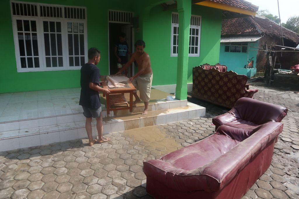 Warga membersihkan lumpur sisa banjir di Kelurahan Kalijaga, Kota Cirebon, Jawa Barat, Selasa (14/1/2020). Sebelumnya, banjir dengan ketinggian 10 sentimeter hingga lebih dari 1 meter merendam sekitar 200 rumah, Senin (13/1/2020).