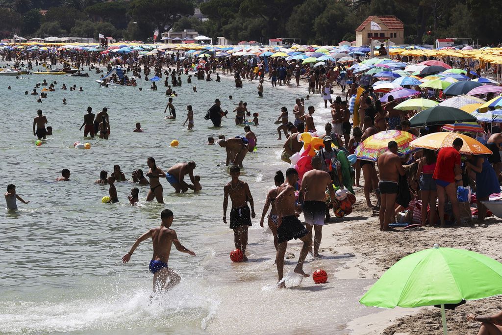 Warga memadati Pantai Mondello, Palermo, Sisiila, Italia, Minggu (16/7/2023). Suhu udara di kota itu mencapai 40 derajat celsius dan membuat warga mencari kesejukan dengan mengunjungi pantai.  