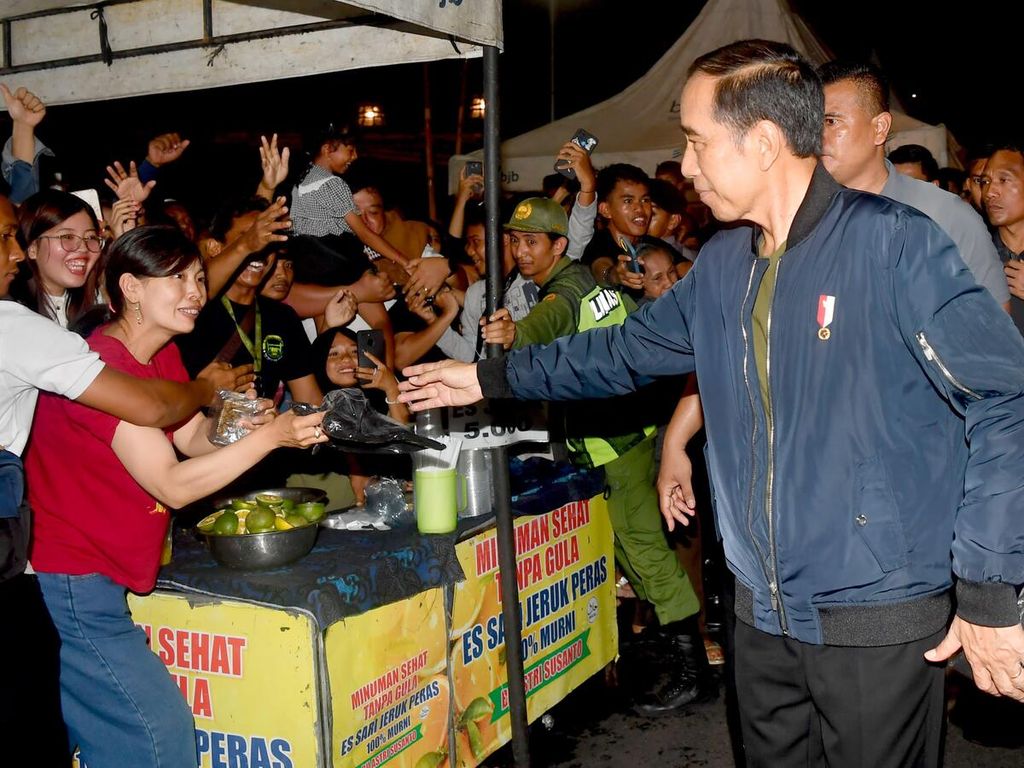 Presiden Joko Widodo saat menyapa warga pada malam menjelang pergantian tahun di Kota Surakarta, Jawa Tengah, Minggu (31/12/2023). 