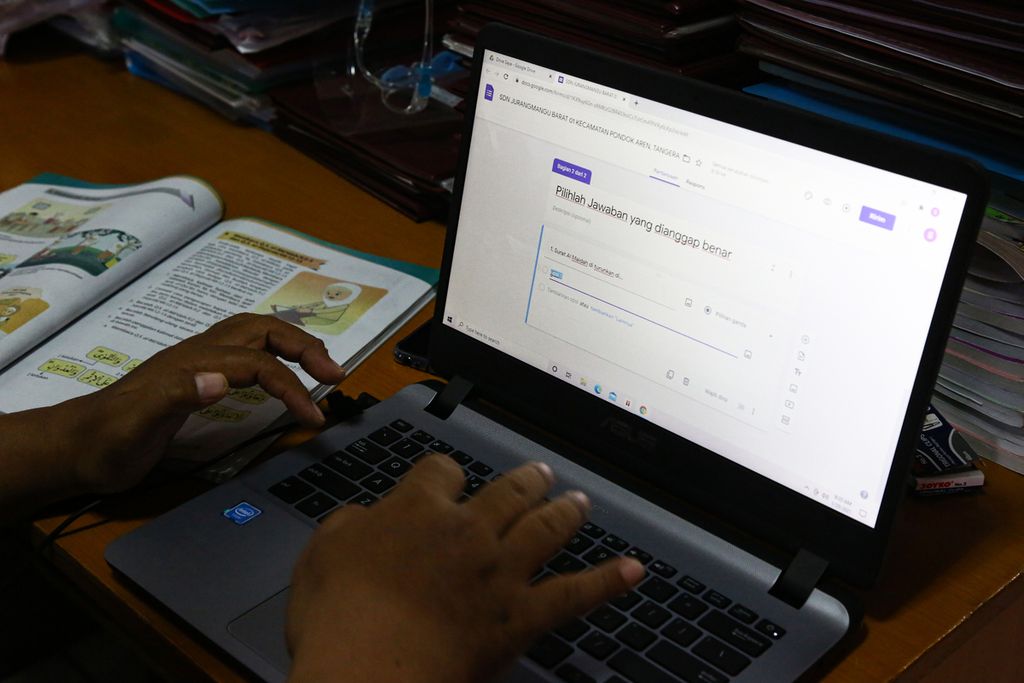 Syukron, guru agama Islam bagi siswa kelas lima dan enam, mempersiapkan bahan penilaian harian yang akan diunggah ke platform pembelajaran jarak jauh Google Form di SD Negeri Jurang Mangu Barat 01, Tangerang Selatan, Banten, Jumat (29/1/2021). 