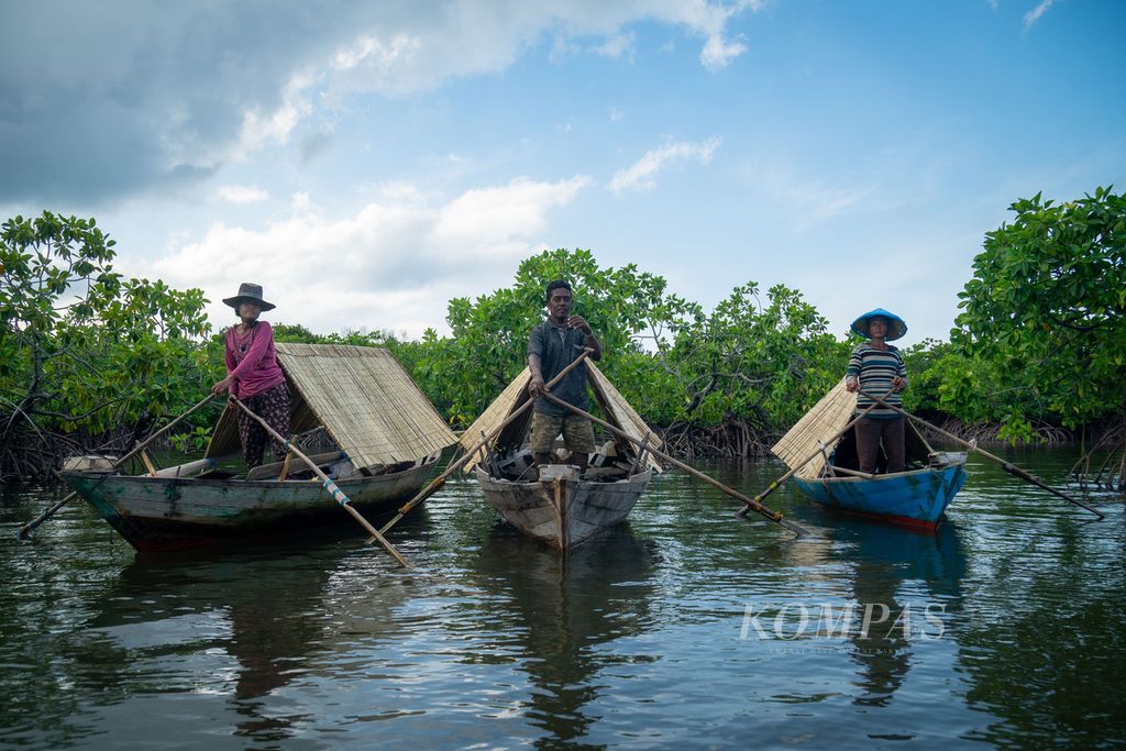 Tiga warga suku Laut menggunakan sampan dayung beratap kajang (semacam daun nipah) untuk hidup secara nomaden atau berpindah-pindah di perairan sekitar Kabupaten Lingga, Kepulauan Riau, Senin (18/7/2022).