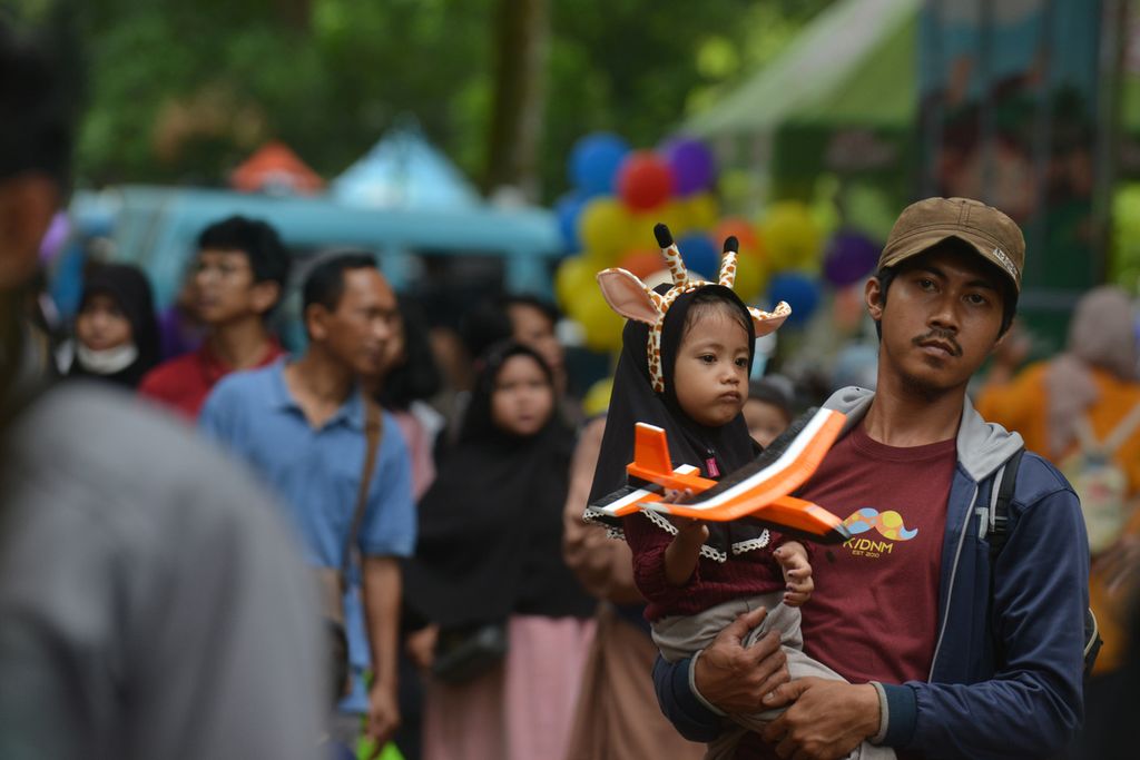 Seorang anak menggunakan bando berbentuk tanduk jerapah di Kebun Binatang Ragunan, Jakarta Selatan, Minggu (25/12/2022). 
