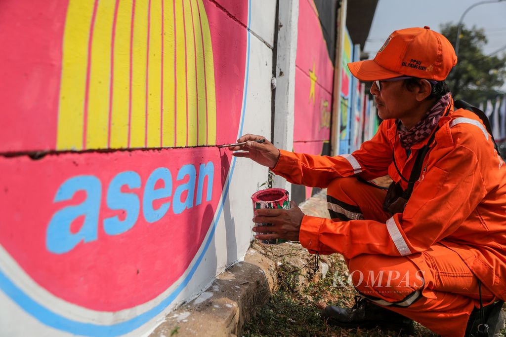 Petugas penanganan prasarana dan sarana umum (PPSU) menyelesaikan pekerjaannya di Jalan Taman Mini I, Pinang Ranti, Jakarta Timur, Rabu (30/8/2023). Pemerintah Kota Jakarta Timur mempercantik sejumlah tembok untuk menyambut Konferensi Tingkat Tinggi ASEAN.