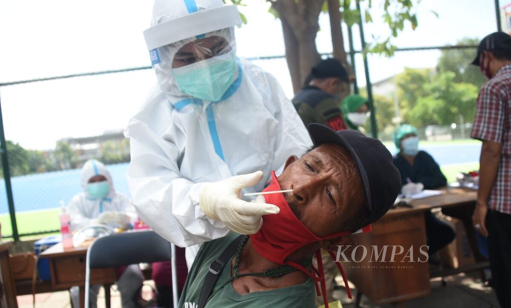 Petugas melakukan tes cepat antigen kepada pedagang kaki lima yang berjualan di sekitar RSUD Dr Soetomo di Kawasan Lapangan Softball Dharmawangsa, Kota Surabaya, Jawa Timur, Minggu (13/6/2021). 