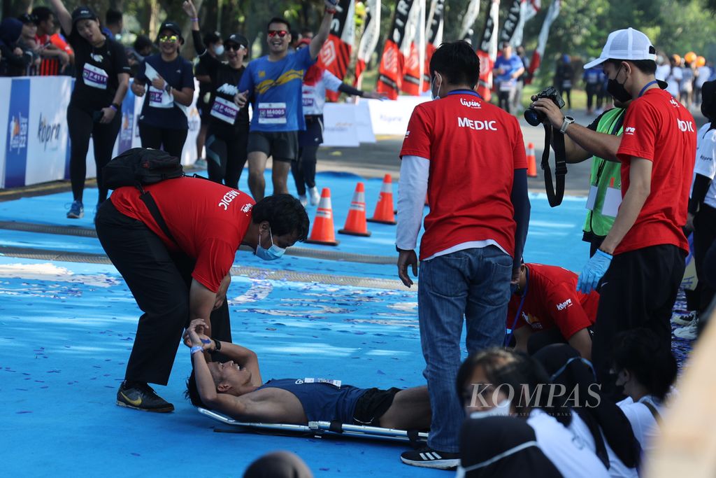 Pelari Atjong Tio Purwanto dihampiri tim medis setelah berhasil finis pertama pada kategori maraton putra dalam lomba Mandiri Jogja Marathon 2022 di kawasan Candi Prambanan, Sleman, DI Yogyakarta, Minggu (14/8/2022). 