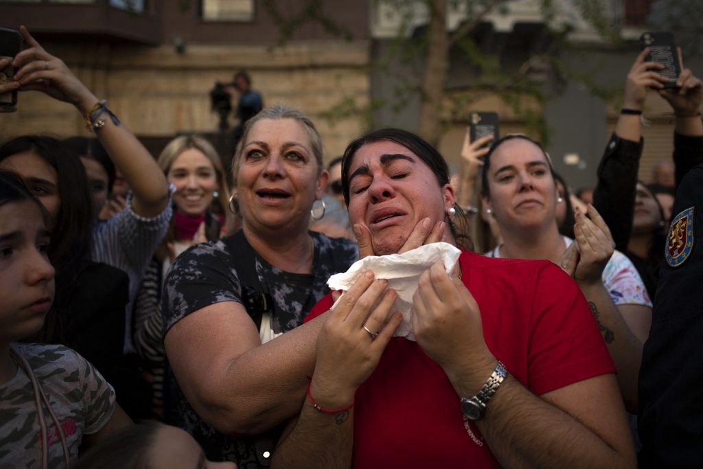 Seorang wanita menangis saat menyaksikan prosesi di Granada, Spanyol, Rabu (5/4/2023).