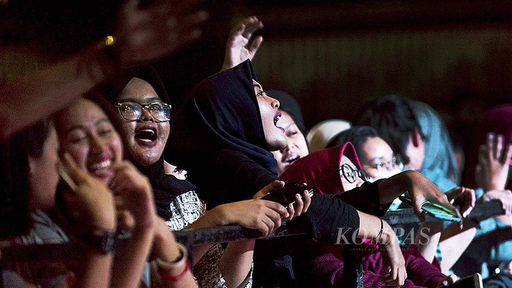 Penonton menikmati lagu yang dibawakan Barasuara saat pentas di sebuah kampus di Jakarta, Kamis (18/5). 