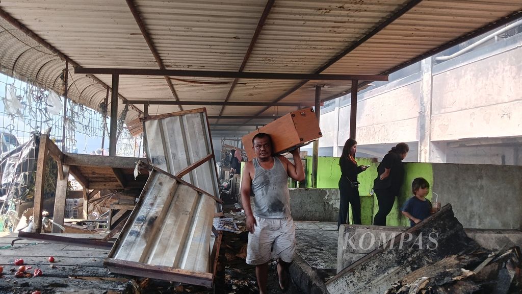 Seorang pedagang Pasar Leuwiliang, Kabupaten Bogor, Jawa Barat, menyelamatkan sisa-sisa barang dagang, Kamis (28/9/2023).