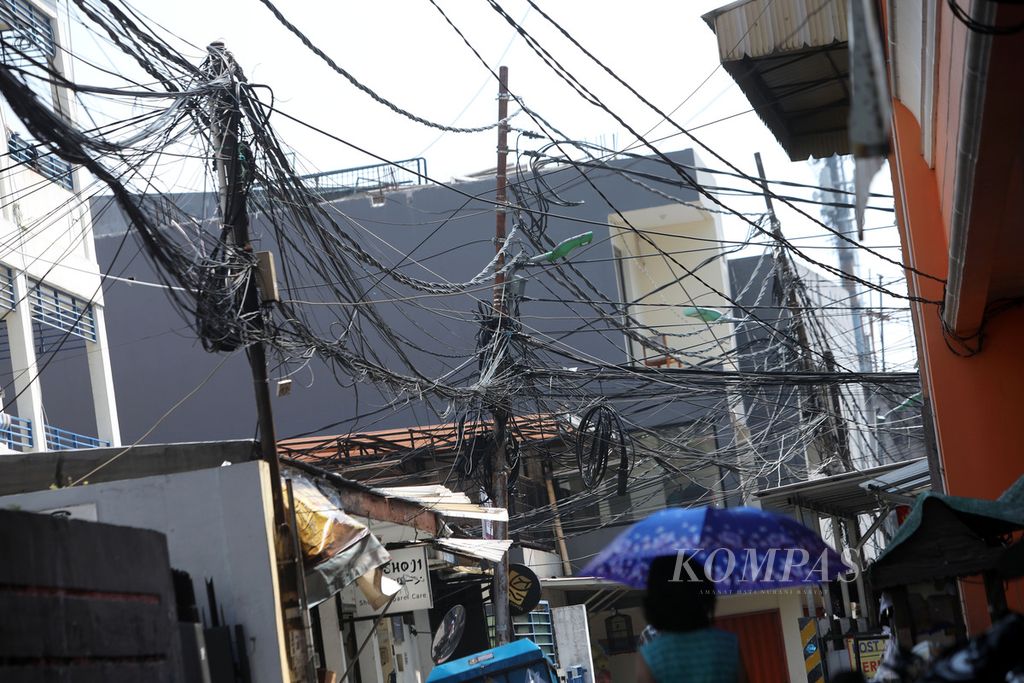 Kabel utilitas yang terlihat semrawut di Jalan Keluarga, Palmerah, Jakarta Barat, Selasa (1/8/2023).