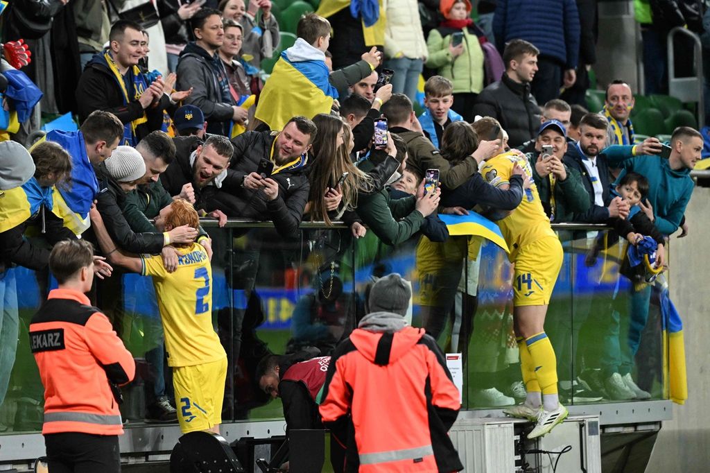 Ukrainian players and supporters celebrate after the European Cup qualifying play-off final match between Ukraine and Iceland at Wroclaw Stadium, Poland, Wednesday (27/3/2024). Ukraine won 2-1 and qualified for the 2024 European Cup finals.