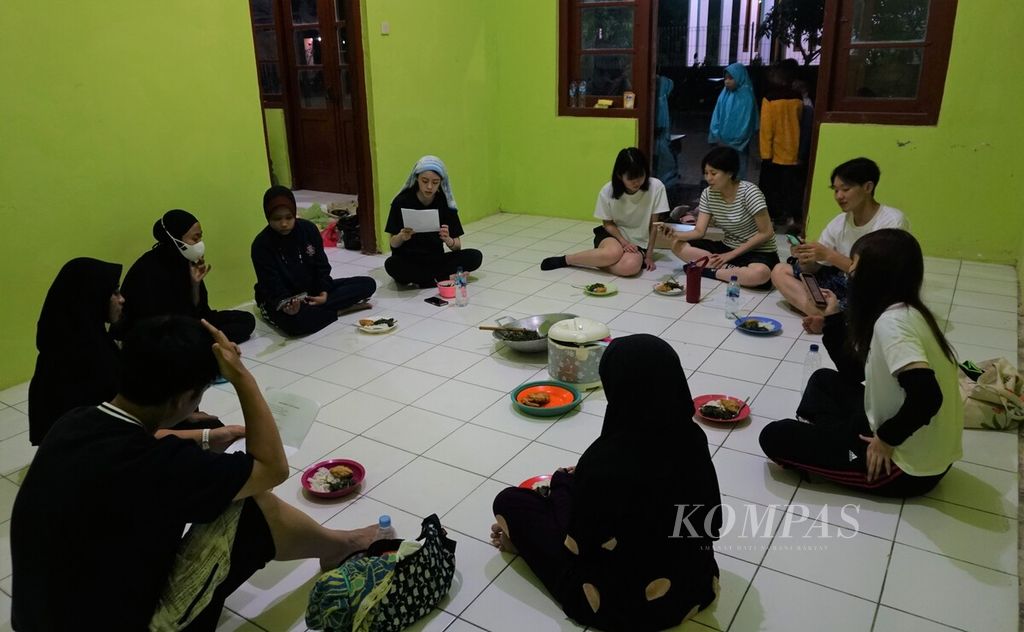 Anak muda dari Jepang dan Indonesia peserta kemah kerja Leprosy Care Community di Nganget, Tuban, bersiap makan malam. Mereka mengunjungi orang dengan kusta di Nganget pada Agustus 2022.