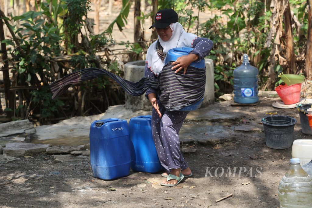 Rukini (42) is drawing water from a well on the edge of a field in Bogor Krajan Hamlet, Bojong Village, Wonosegoro, Boyolali, Central Java, on Monday (4/9/2023). The community hopes that the government will reactivate the Community-Based Drinking Water and Sanitation Provision Program (Pamsimas) facilities that have been built in the hamlet but are not functioning.