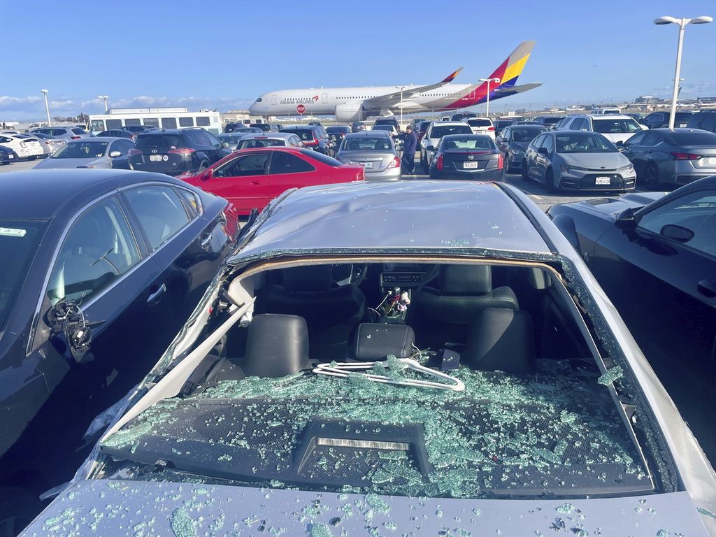 Mobil yang rusak akibat tertimpa serpihan ban Boeing 777 terlihat di tempat parkir karyawan bandara di Bandara Internasional San Francisco, AS, 7 Maret 2024.