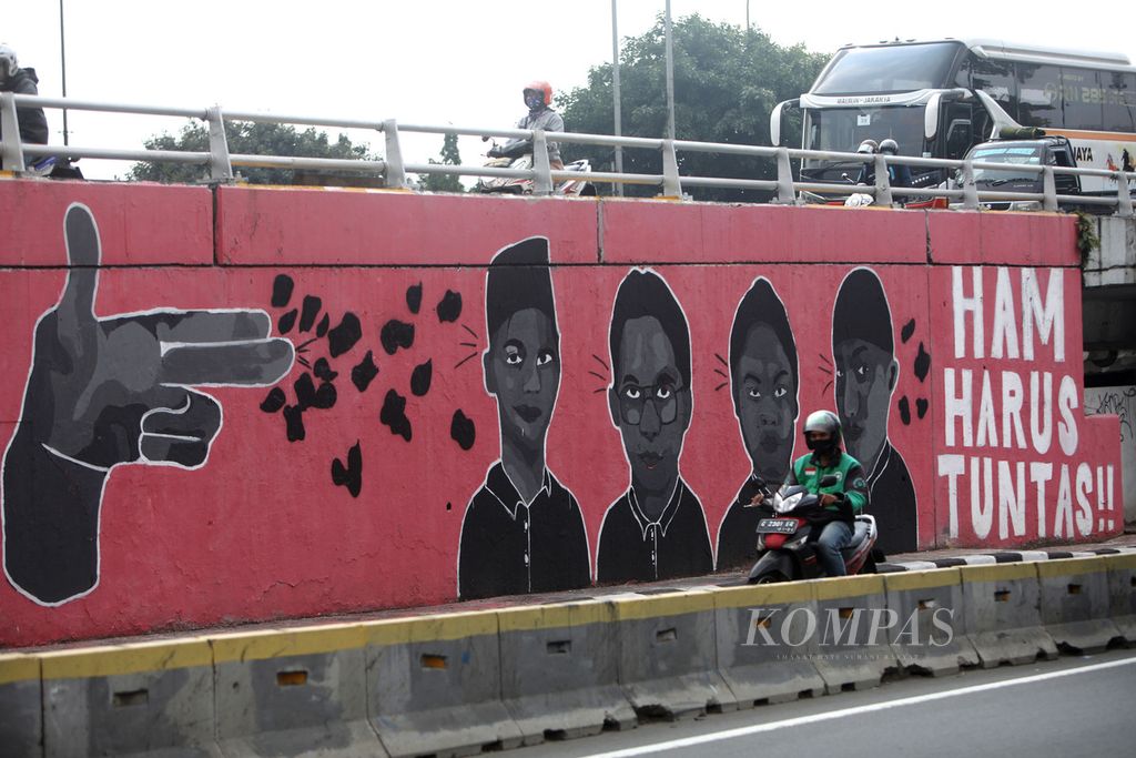 Mural berisi tuntutan untuk penuntasan kasus pelanggaran HAM menghiasi Jembatan layang Grogol di depan Kampus Universitas Trisakti, Jakarta, Kamis (28/7/2022). Saat ini Mahkamah Agung meloloskan delapan nama calon hakim <i>ad hoc</i> pelanggaran Hak Asasi Manusia (HAM) berat Paniai, Papua. 