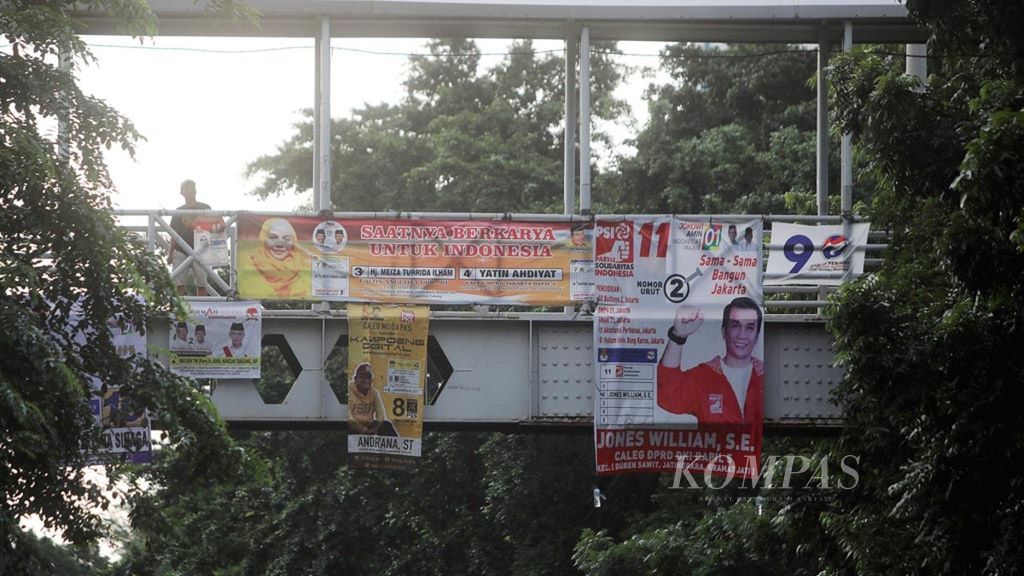 Alat peraga kampanye (APK) Pileg dan Pilpres 2019 terpasang di jembatan penyeberangan orang di kawasan Cipinang Besar, Jakarta Timur, Rabu (3/4/2019). Sejumlah area yang terlarang untuk pemasangan APK dan sebelumnya telah ditertibkan petugas satpol PP bersama Bawaslu, tetapi saat ini terlihat kembali dipasang spanduk APK.
