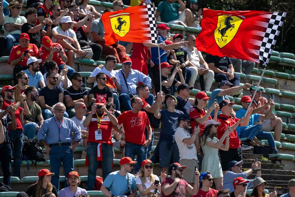 Tifosi Ferrari mengibarkan bendera saat menonton sesi latihan Formula 1 seri Emilia Romagna di Sirkuit Imola, Jumat (17/5/2024). 