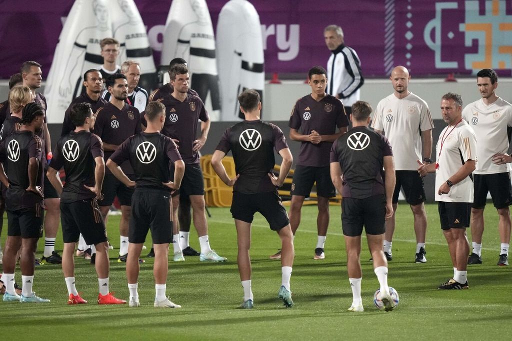 Pelatih Jerman Hansi Flick (kanan) berbincang dengan pemainnya pada sesi latihan di Stadion Al-Shamal, Qatar, Jumat (25/11/2022). Mereka akan menghadapi Spanyol pada laga penyisihan grup Piala Dunia Qatar 2022, Senin (28/11/2022) dini hari WIB. 
