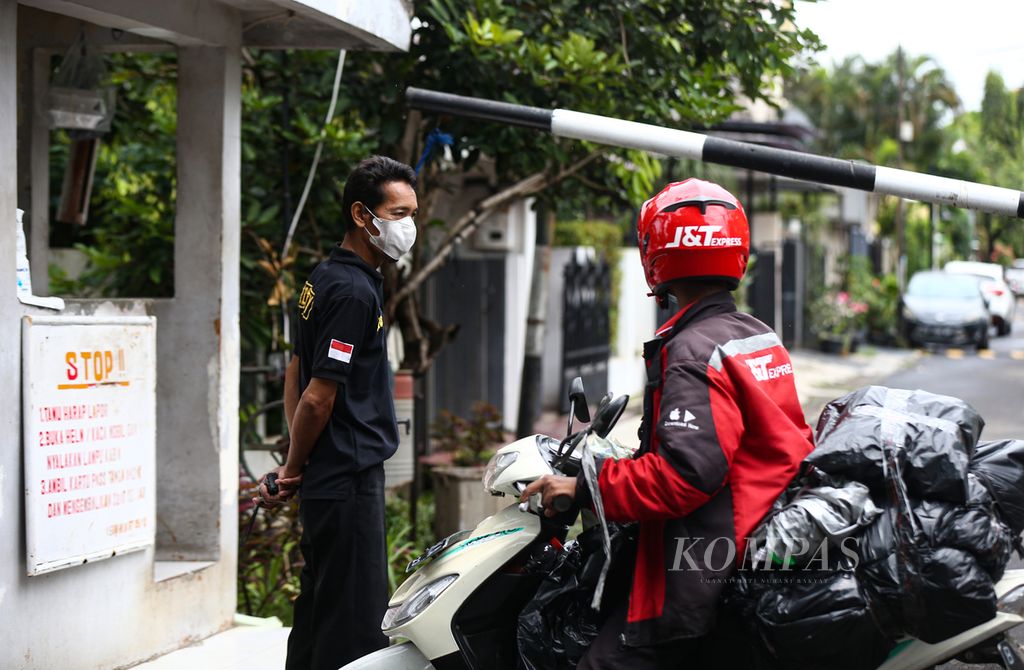Amin, petugas satpam komplek menanyai pengantar paket sebelum diizinkan melintas di area perumahan di kawasan Bintaro, Pondok Aren, Tangerang Selatan, Banten , Jumat (25/2/2022). 