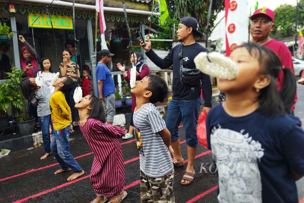 Hujan deras tidak menyurutkan antusiasme dan keceriaan anak-anak di Kelurahan Sukabumi Utara, Kebon Jeruk, Gelora, Jakarta Barat, mengikuti lomba makan kerupuk, Rabu (17/8/2022). Setelah dua tahun tidak ada pesta rakyat karena pandemi Covid-19, anak-anak bisa kembali memeriahkan HUT Ke-77 RI.