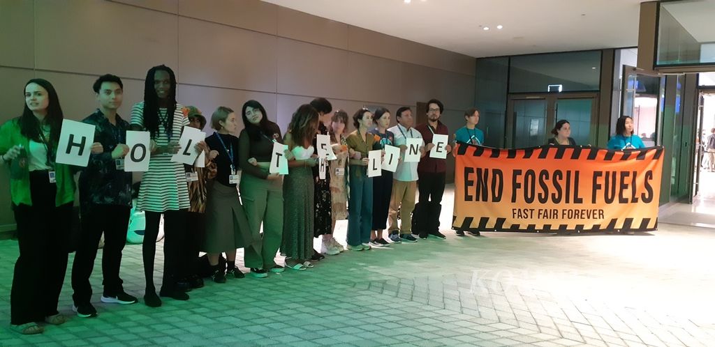 Aktivis menyuarakan pengakhiran energi fosil di depan pintu masuk Gedung B8 di Dubai Expo, Dubai, Uni Emirat Arab, Senin (11/12/2023). Aksi itu dilaksanakan pada saat para pihak merundingkan hasil akhir COP28 untuk memperbarui kebijakan aksi perubahan iklim.