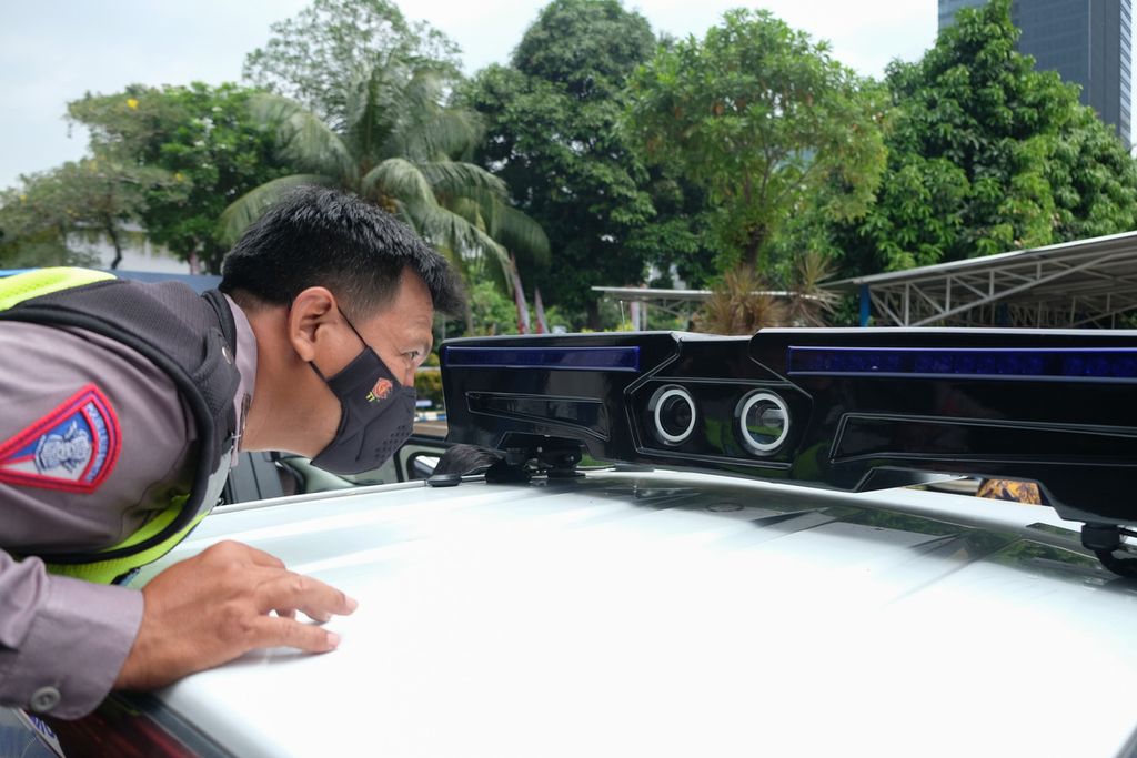 Anggota polisi melihat kamera Electronic Traffic Law Enforcement (ETLE) mobile yang terpasang di bagian atas mobil di halaman gedung Direktorat Lalu Lintas (Ditlantas) Polda Metro Jaya, Jakarta, Jumat (9/12/2022). 