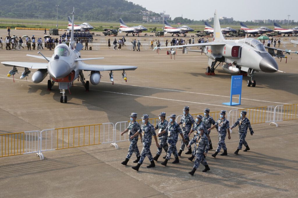 Personel Angkatan Udara China berbaris melewati pesawat tempur J10C dan pesawat pengebom JH-7A2 milik militer China selama Pameran Penerbangan dan Dirgantara Internasional China ke-13, yang juga dikenal sebagai Airshow China 2021, Rabu, 29 September 2021, di Zhuhai di Provinsi Guangdong, China selatan. 