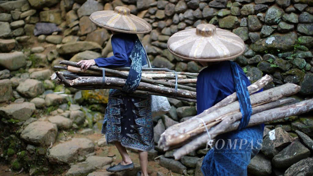 Perempuan Baduy membawa kayu bakar melewati jalan berundak di Kampung Balimbing, Desa Kanekes, Kecamatan Leuwidamar, Kabupaten Lebak, Banten, Kamis (16/3/2023).