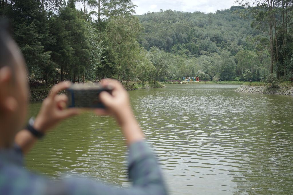 Pengunjung mengambil gambar pemandangan Situ Cisanti, Kabupaten Bandung, Jawa Barat, pada Minggu (5/2/2023). Situ Cisanti diyakini sebagai sumber air Sungai Citarum.