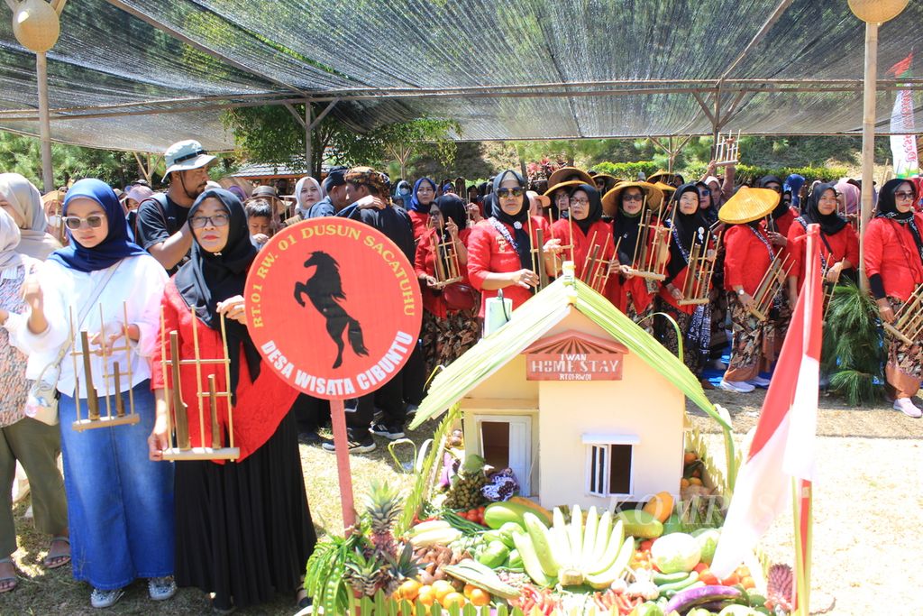 Warga dan pengunjung bermain angklung dalam acara Sedekah Bumi di Desa Cibuntu, Kecamatan Pasawahan, Kabupaten Kuningan, Jawa Barat, Sabtu (7/9/2024). Selain melestarikan tradisi, kegiatan itu juga untuk menarik kunjungan wisatawan. Sejak 2012, Cibuntu yang daerahnya bekas galian C mulai menjelma menjadi desa wisata.