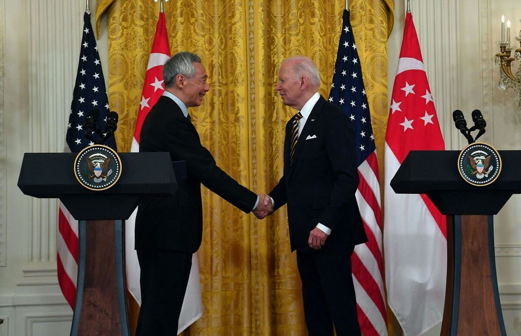 Presiden Amerika Serikat Joe Biden berjabat tangan dengan Perdana Menteri Singapura Lee Hsien Loong dalam keterangan pers bersama di Ruang Timur Gedung Putih, Washington, DC, Selasa (29/3/2022). (Photo by Nicholas Kamm / AFP)