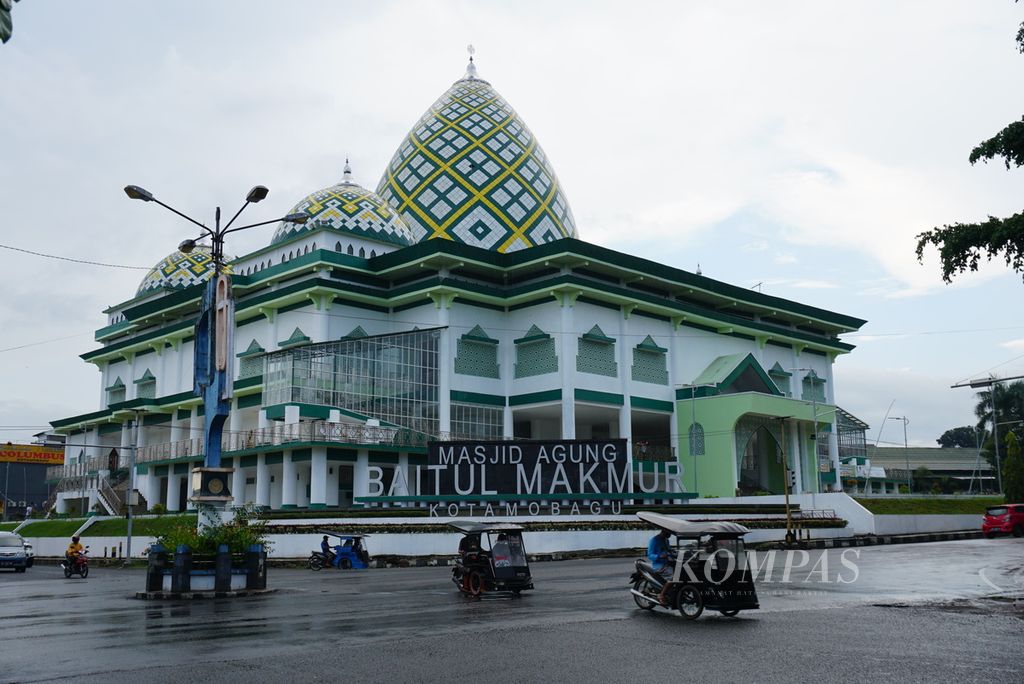 Beberapa bendi motor atau bentor melintas di muka Masjid Agung Baitul Makmur, Kotamobagu, Sulawesi Utara, jelang waktu berbuka puasa, Selasa (4/5/2021). Masjid itu selesai dibangun pada 2020 dengan dana Rp 2,4 miliar.