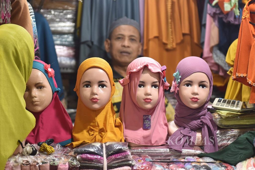 Peadagang menunggu pembeli di Pasar Pabean, Kota Surabaya, Jawa Timur, Kamis (23/3/2022). Tingkat penjualan meningkat di pasar tersebut sejalan semakin dekatnya bulan Ramadhan. Sebagian besar pembeli adalah penjual jilbab di Pulau Madura dan daerah sekitar Surabaya. 
