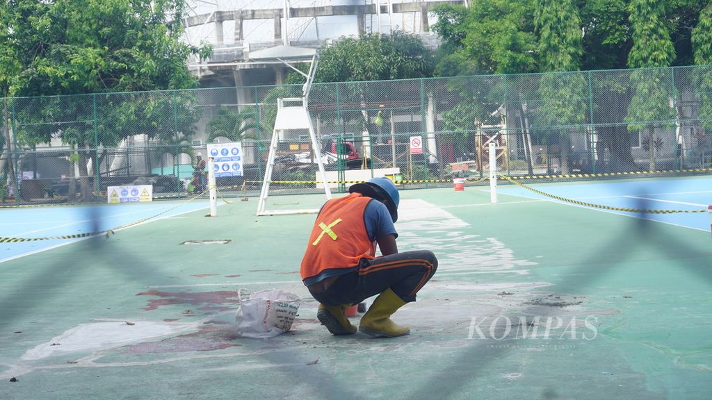 Pekerja menambal lapangan yang retak-retak di Lapangan Tenis Manahan, Kota Surakarta, Jawa Tengah, Jumat (17/6/2022). Lapangan tersebut menjadi salah satu arena pertandingan yang akan digunakan untuk ASEAN Para Games 2022. Semua arena pertandingan ditargetkan rampung direnovasi pada 20 Juli 2022.