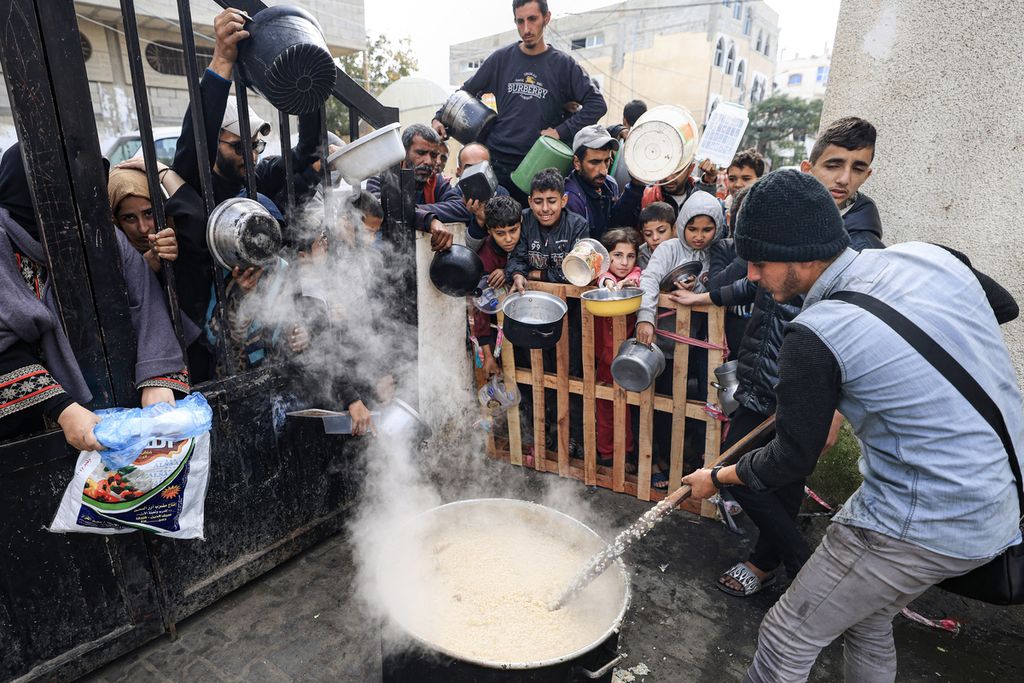 Pengungsi Palestina di Rafah menanti jatah makanan gratis pada Desember 2023.