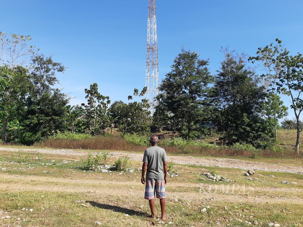 Rafael difoto saat mengamati menara pemancar di Turiskain, Kabupaten Belu, NTT, dekat garis batas dengan Timor Leste, Jumat (8/7/2022). Di menara yang sudah tidak lagi berfungsi itu masih terdeteksi sinyal dari Timor Leste.