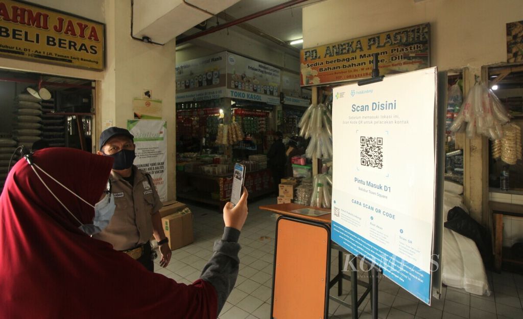 Pengunjung memindai kode batang atau <i>barcode</i> pada aplikasi Peduli Lindungi di Pasar Balubur Town Square (Baltos) dan Pasar Sederhana, Kota Bandung, Rabu (6/10/2021).