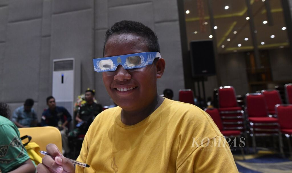 Brayen Perdo Tinay (13), siswa SMP YPPK, senang mencoba kacamata untuk melihat gerhana Matahari yang dibagikan kepada peserta seminar Festival Gerhana Matahari di Biak Numfor, Papua, Rabu (19/4/2023). 