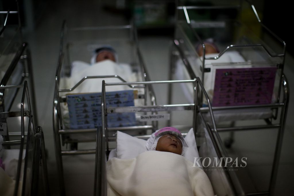 Bayi yang baru lahir terlelap di ruang bayi Rumah Sakit Ibu dan Anak Tambak, Jakarta, dengan menggunakan pelindung wajah (<i>face shield</i>), Senin (20/4/2020). Kebijakan internal pemasangan pelindung wajah pada bayi yang baru lahir ini dilakukan untuk meminimalkan bayi terpapar virus korona baru melalui droplet.