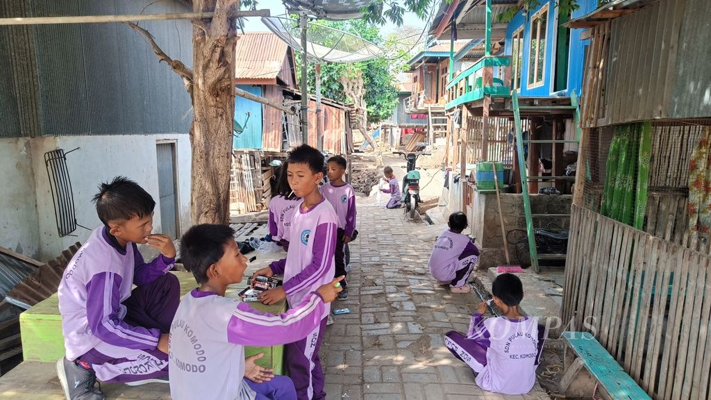 Anak-anak sekolah SDN Satu Atap Pulau Komodo bersantai di hari-hari awal masuk sekolah. Kegiatan belajar-mengajar belum dimulai tetapi mereka tetap diminta untuk bersekolah di Pulau Komodo, Manggarai Barat, Nusa Tenggara Timur, Jumat (5/1/2024).