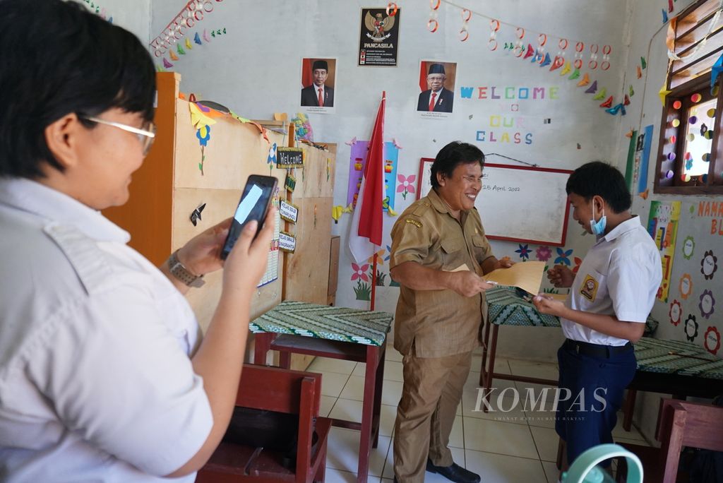 Johanes Disa (44) takes a picture with a mentally retarded student after an exam at the Extraordinary School of Berkat Yosua, Kamangta Village, Minahasa, North Sulawesi, on Monday (25/4/2022). Johanes is an honorary teacher with a salary of IDR 300,000 per month.