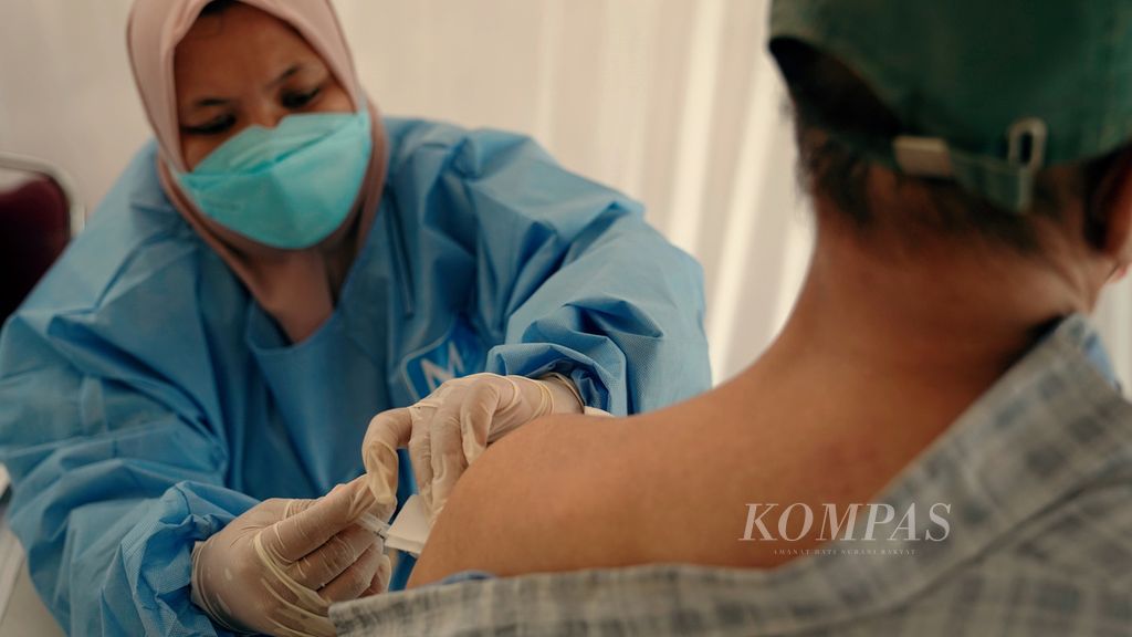 Tenaga kesehatan melayani vaksinasi penguat untuk warga lansia di RPTRA Matahari, Kelurahan Cempaka Putih Timur, Kecamatan Cempaka Putih, Jakarta Pusat, Kamis (13/1/2022). Puskesmas Kecamatan Cempaka Putih dalam dua hari itu melayani vaksinasi penguat jenis Pfizer untuk warga lansia. Warga lansia yang sudah menerima tiket vaksin di aplikasi Peduli Lindungi bisa mendaftar dan mendapatkan vaksinasi ketiga di tempat tersebut.