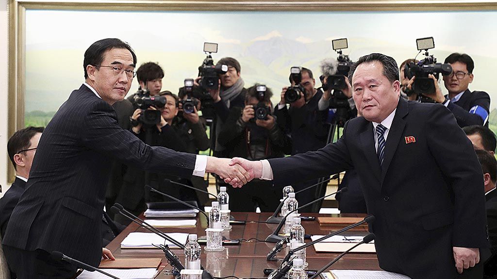 Kepala delegasi  Korea Utara Ri Son Gwon (kanan) berjabat tangan dengan Menteri Unifikasi Korea Selatan Cho Myoung-gyon (kiri) setelah pertemuan mereka, Selasa (9/1) di Panmunjom, Paju, Korea Selatan. Kedua negara sepakat mengurangi permusuhan. 