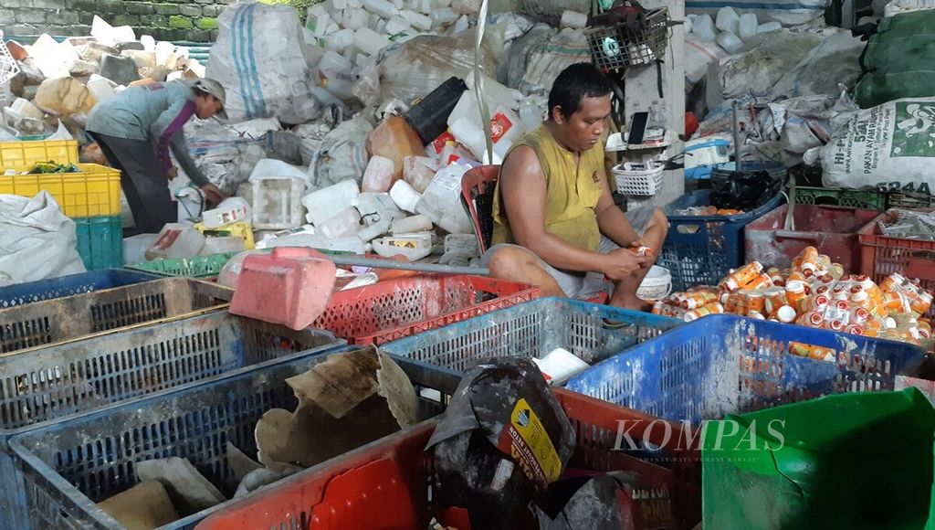 Pekerja memilah dan memisahkan sampah plastik kemasan di sebuah tempat pengumpulan sampah plastik di Kota Denpasar, Bali, Jumat (10/2/2023). Sejumlah jenis sampah plastik kemasan masih memiliki nilai ekonomi dan dapat didaur ulang.