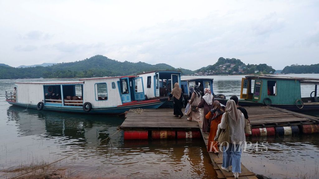 Pengunjung naik ke kapal di Dermaga Pulau Ratu usai menikmati wisata kuliner di rumah makan terapung di Waduk Riam Kanan, Desa Tiwingan Lama, Kecamatan Aranio, Kabupaten Banjar, Kalimantan Selatan, Sabtu (14/1/2023). 