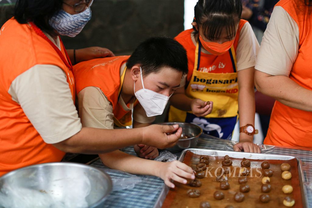 Siswa <i>down syndrome </i>tampak antusias saat mengikuti pelatihan membuat kue kering Puppy Cookies di Sekolah Kebutuhan Khusus Sang Timur, Karang Tengah, Kota Tangerang, Banten, Senin (21/3/2022). Kegiatan yang diikuti 33 siswa itu dalam rangka memperingati Hari Down Syndrome Sedunia.
