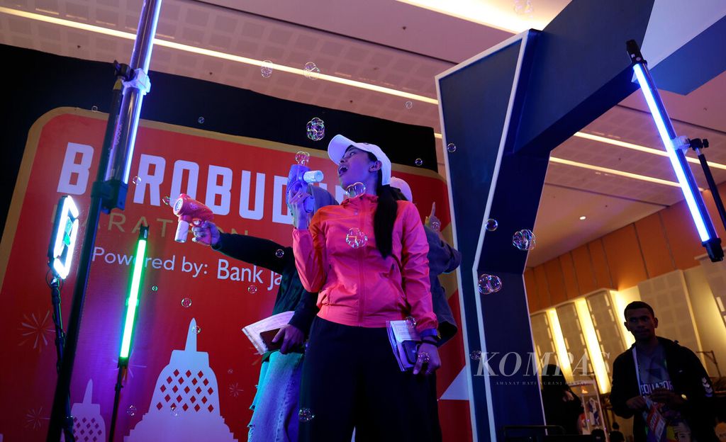 Peserta lari Borobudur Marathon 2022 Powered by Bank Jateng mendapat kesempatan berfoto saat mengunjungi salah satu stan pameran di Hotel Artos, Kota Magelang, Jawa Tengah, Jumat (11/11/2022). Menjelang penyelenggaraan Borobudur Marathon 2022 pada 12-13 November, sejumlah kegiatan dilakukan, antara lain, pengambilan perlengkapan pelari serta pameran kuliner dan produk olahraga. 