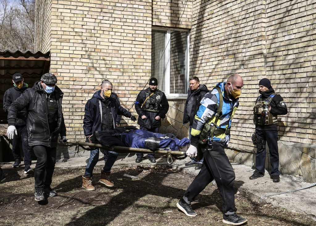 Mayat dievakuasi dari sebuah sekolah di Bucha, barat laut ibu kota Ukraina, Kiev, Senin (4/4/2022).